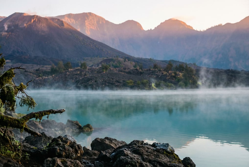 A volcanic caldera lake, perfectly still turquoise water surrounded by dark ash-covered slopes and w