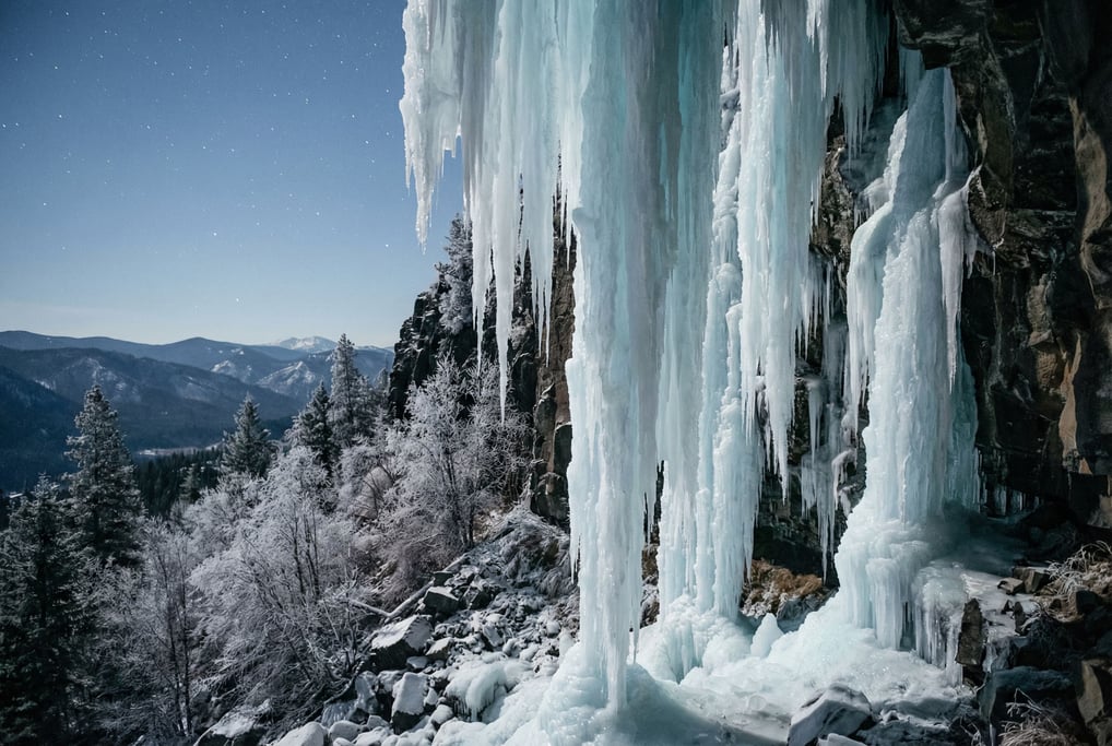 A frozen waterfall cascading down a basalt cliff face, ice formations in pale blue and white (higjvufx)