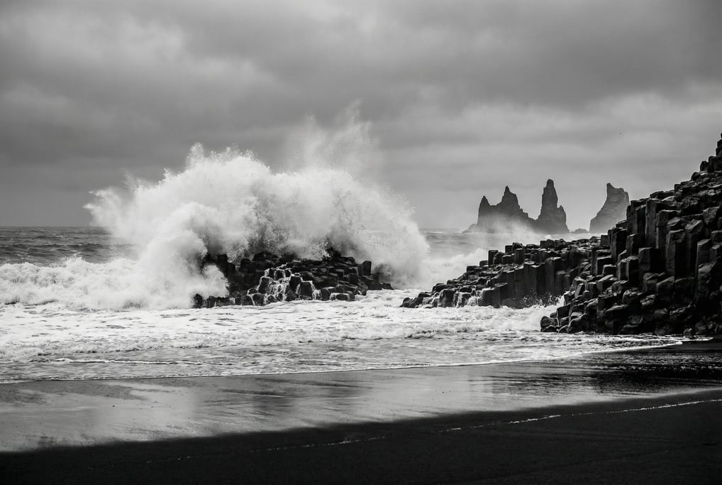 A wave crashing against the Reynisfjara black sand beach in Iceland