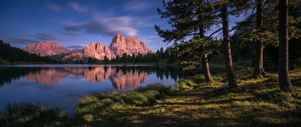 Dolomite towers glowing pink in alpenglow, vertical limestone pillars against a deep twilight sky (naqlnb3h)