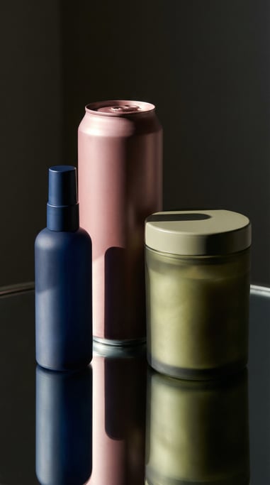 Spray bottle in matte navy and slim aluminum can in matte dusty rose and candle jar with lid in matt