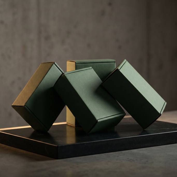 Kraft cardboard box, four boxes arranged at slight angles, matte forest green finish