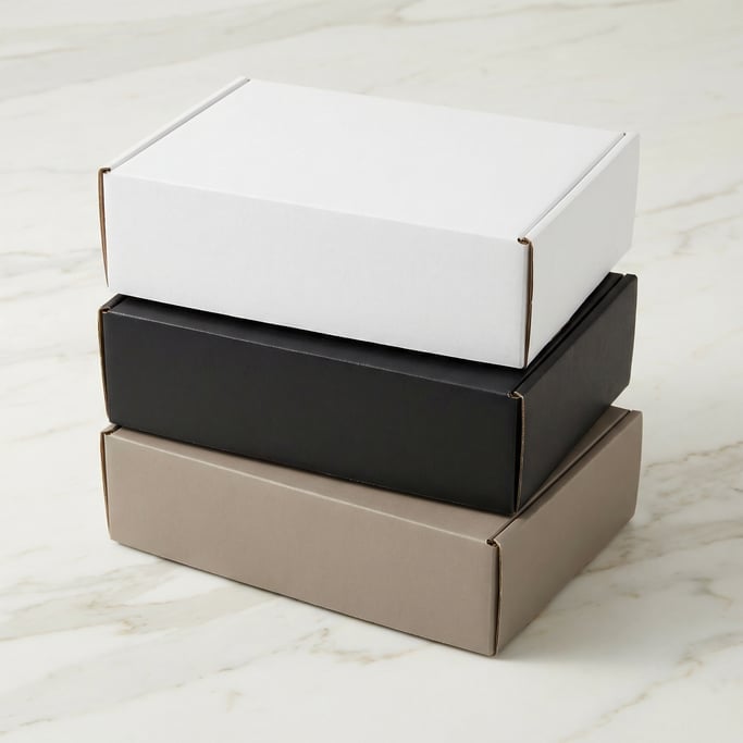 Kraft cardboard box, stack of three boxes, each a different color — matte white, matte black