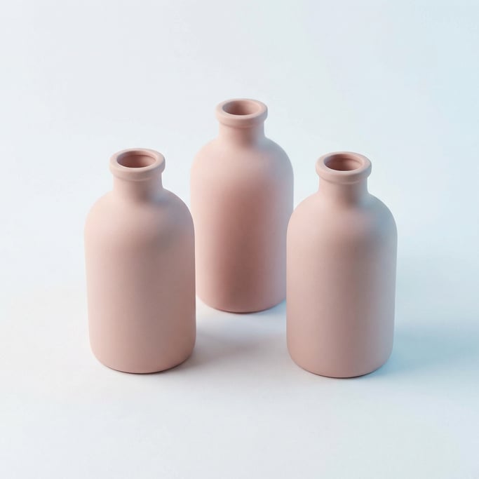 Medicine bottle in matte blush pink, three arranged in a triangle