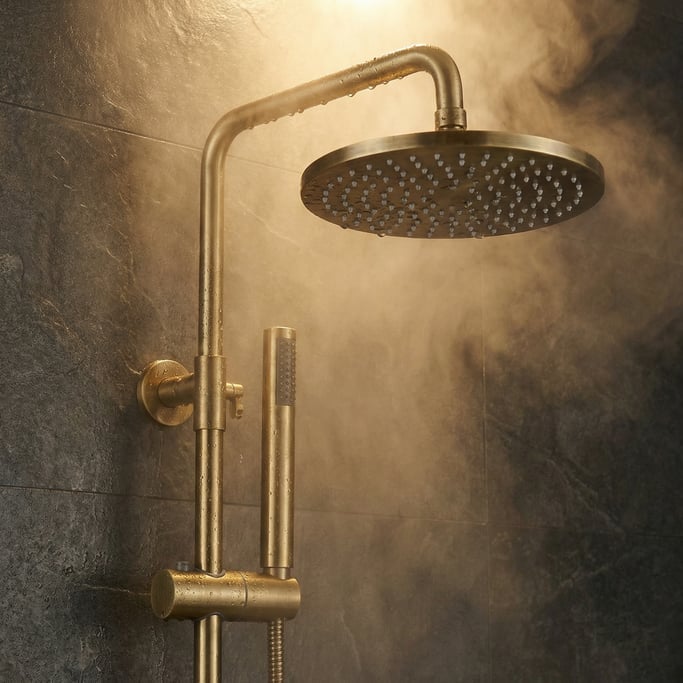 Close-up of a modern brass shower fixture with a rain head and hand wand