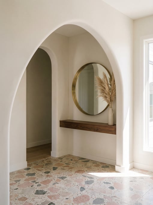 Modern entryway with a curved plaster archway, terrazzo flooring in pink and grey chips