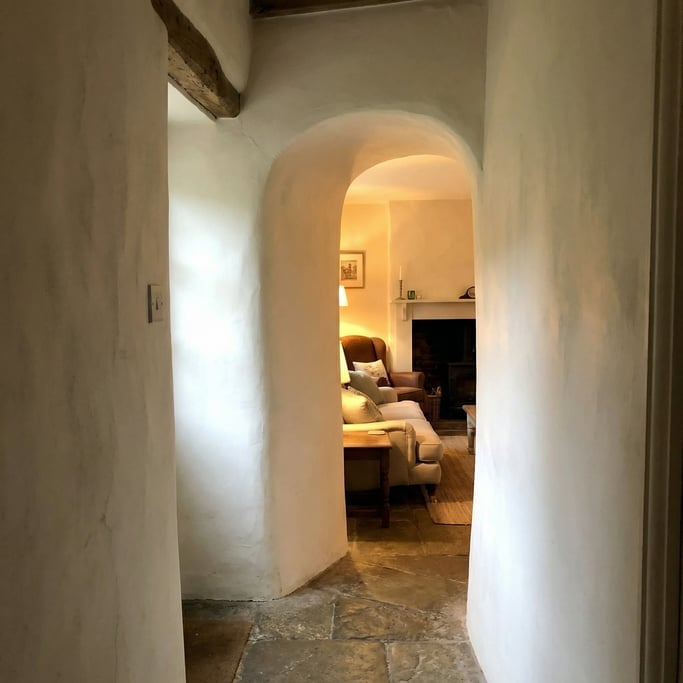 Architectural detail of a plaster archway with rounded edges where a hallway meets a living room