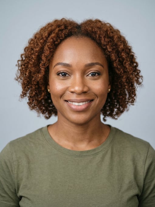 Professional studio headshot of a 31-year-old Nigerian woman with shoulder-length curly auburn hair