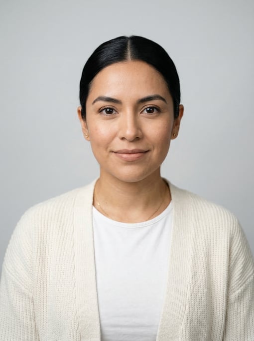 Professional studio headshot of a 29-year-old Mexican woman with a sleek low bun in black