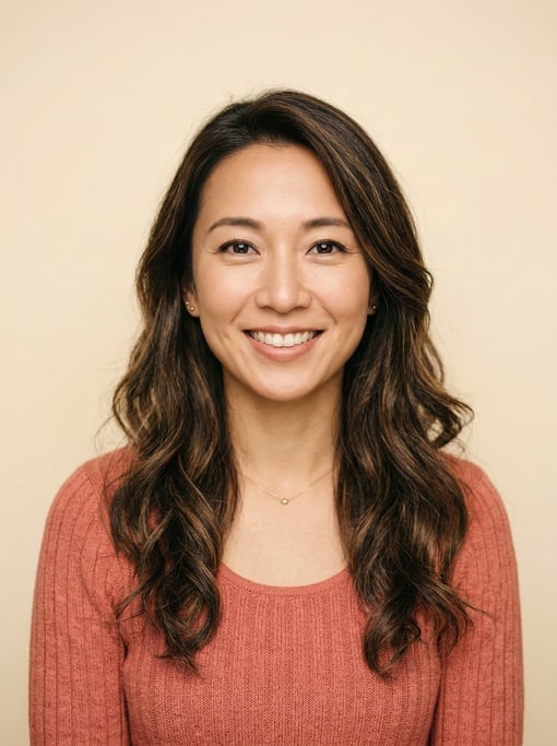 Professional studio headshot of a 34-year-old Japanese woman with long wavy dark brown hair
