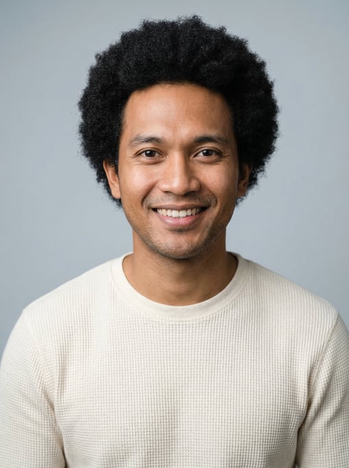 Professional studio headshot of a 30-year-old Indonesian man with a medium natural afro in black