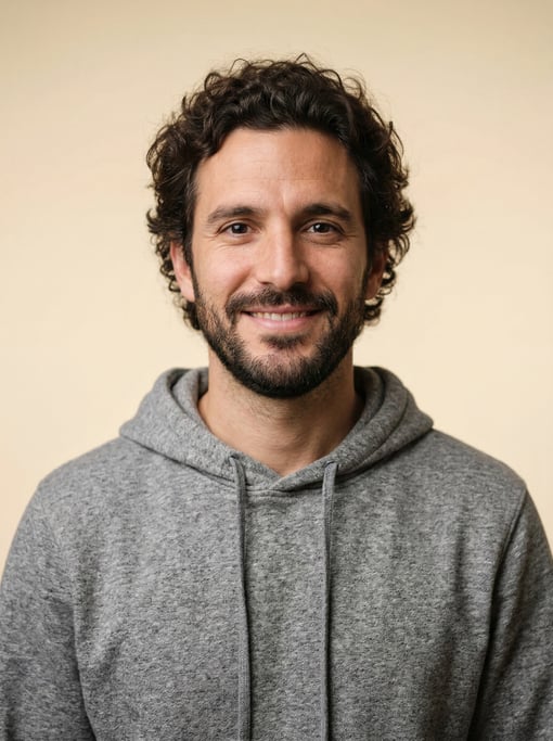 Professional studio headshot of a 31-year-old Argentinian man with medium-length curly dark hair