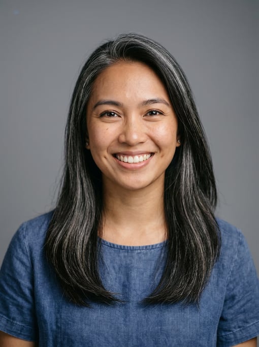 Professional studio headshot of a 24-year-old Filipino woman with long straight silver-streaked dark