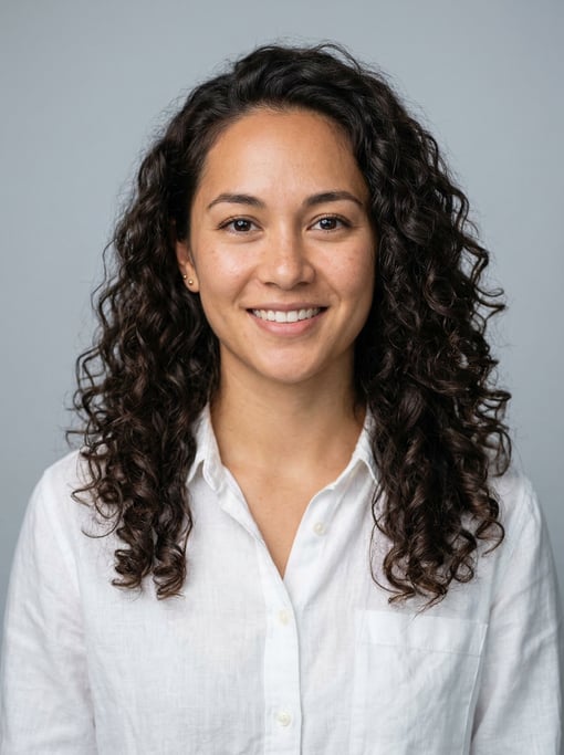 Professional studio headshot of a 26-year-old Hawaiian woman with long loose curls in dark brown