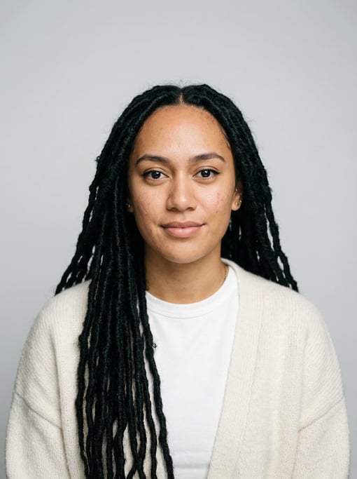 Professional studio headshot of a 24-year-old Maori woman with long faux locs in black