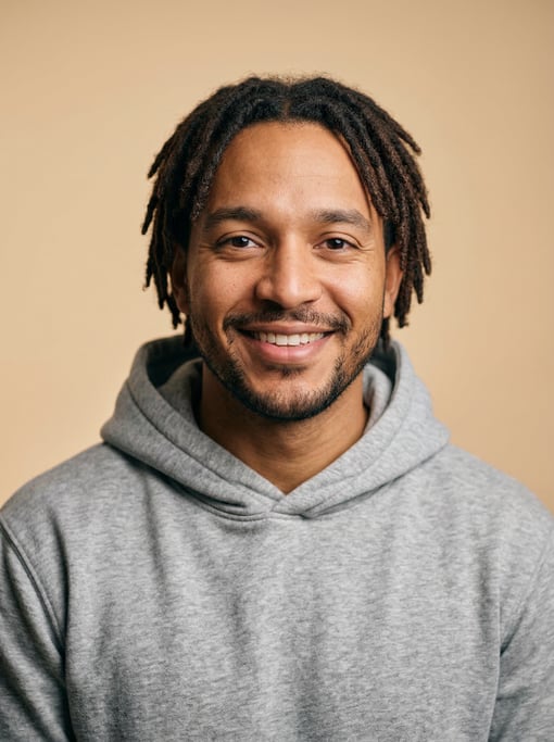 Professional studio headshot of a 29-year-old Latino man with short locs in dark brown
