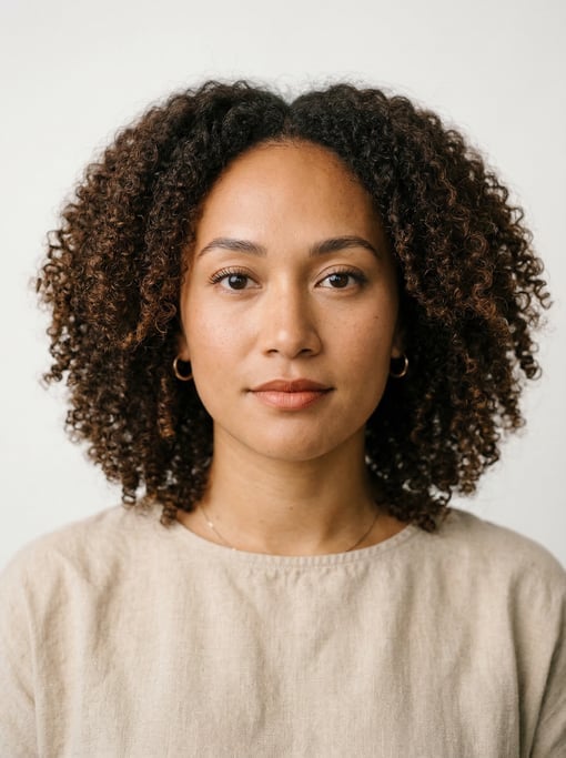 Professional studio headshot of a 27-year-old Hawaiian woman with shoulder-length coily natural hair