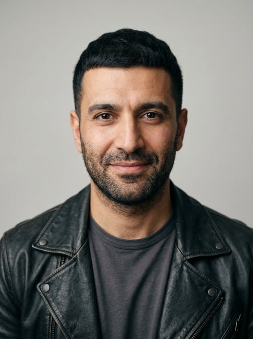 Professional studio headshot of a 39-year-old Middle Eastern man with a Caesar cut in black