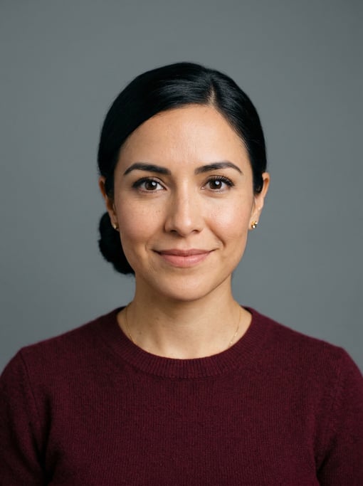 Professional studio headshot of a 34-year-old Mexican woman with a sleek low bun in black
