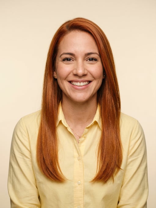 Professional studio headshot of a 34-year-old Cuban woman with long straight copper red hair