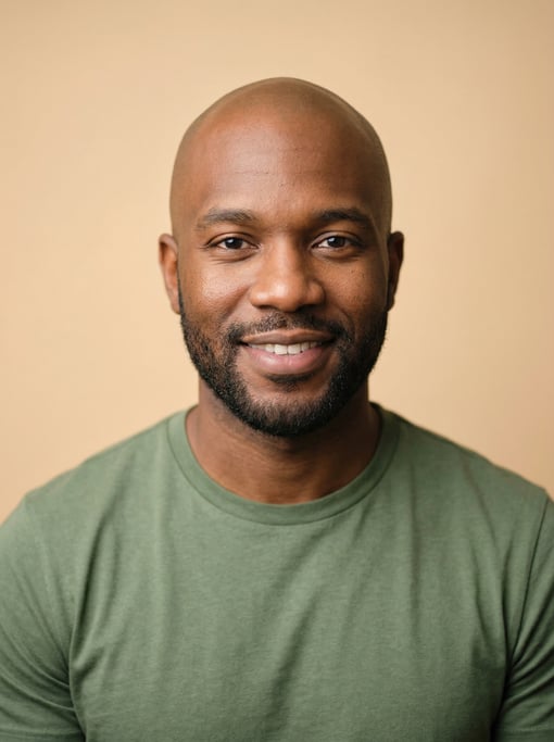 Professional studio headshot of a 32-year-old Black American man with a shaved head