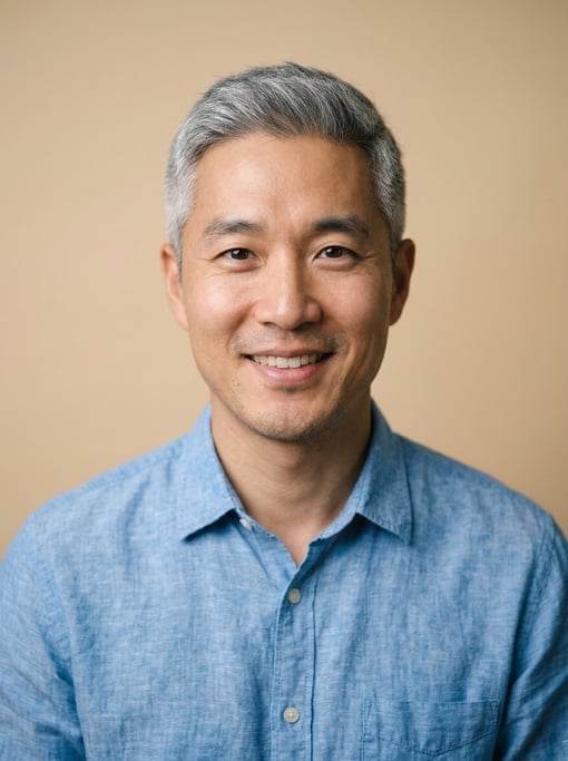 Professional studio headshot of a 35-year-old Korean man with fully grey short cropped hair