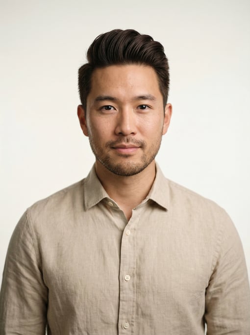 Professional studio headshot of a 28-year-old East Asian man with a pompadour in dark brown
