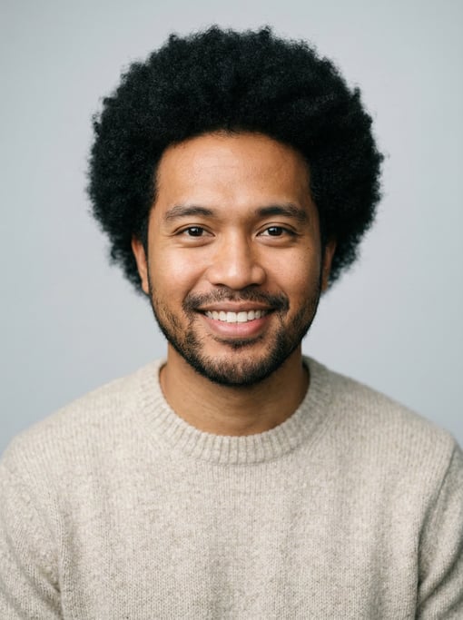 Professional studio headshot of a 29-year-old Filipino man with a medium natural afro in black