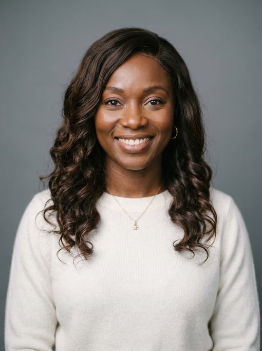 Professional studio headshot of a 38-year-old Ghanaian woman with a deep side part with long brown w