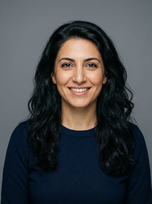 Professional studio headshot of a 34-year-old Persian woman with long wavy black hair