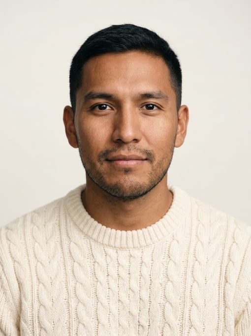 Professional studio headshot of a 28-year-old Native American man with short cropped black hair