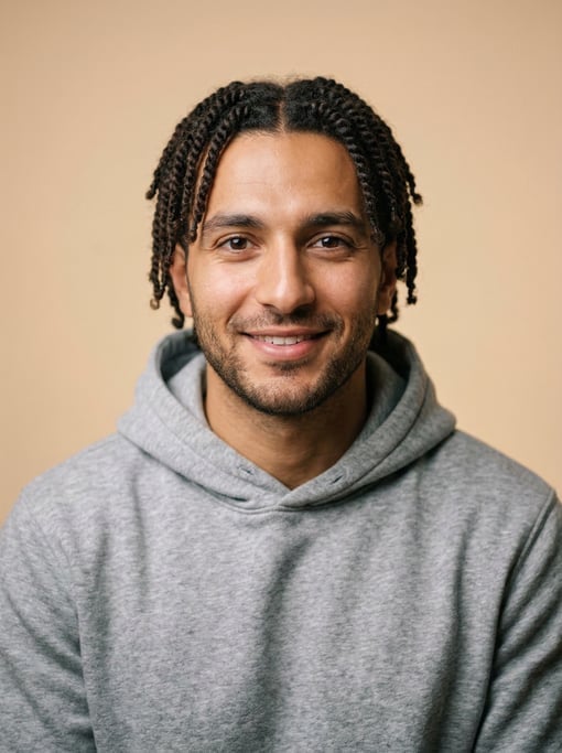 Professional studio headshot of a 25-year-old Lebanese man with twists in dark brown