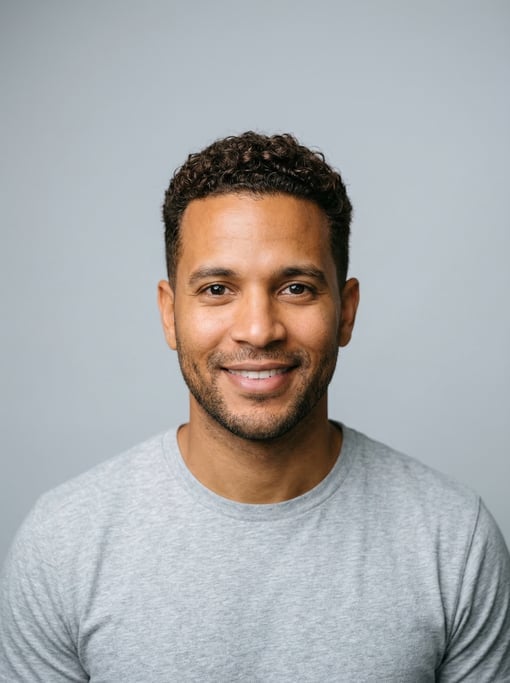 Professional studio headshot of a 34-year-old Dominican man with a dark brown textured crop