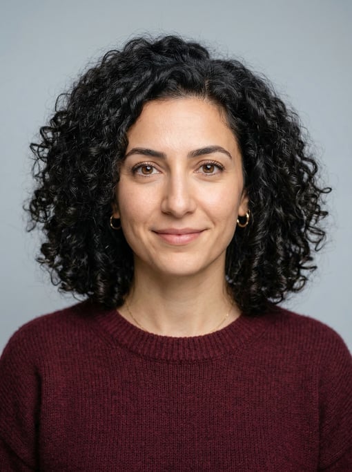 Professional studio headshot of a 35-year-old Lebanese woman with shoulder-length coily natural hair
