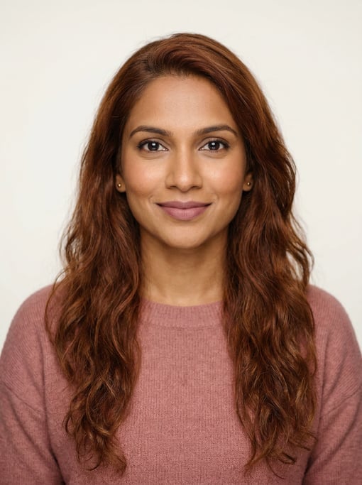 Professional studio headshot of a 32-year-old Sri Lankan woman with long wavy auburn hair