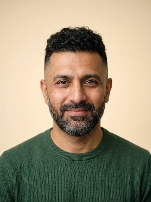 Professional studio headshot of a 40-year-old Pakistani man with a skin fade with longer curly top