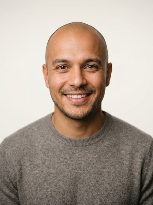 Professional studio headshot of a 30-year-old Brazilian man with a shaved head