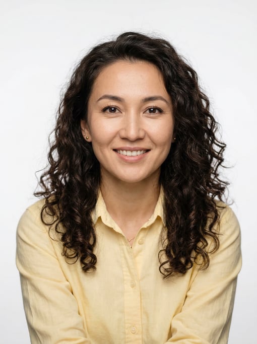 Professional studio headshot of a 33-year-old Central Asian woman with long loose curls in dark brow