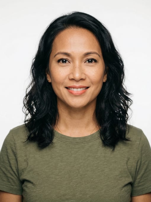 Professional studio headshot of a 40-year-old Southeast Asian woman with shoulder-length wavy dark h