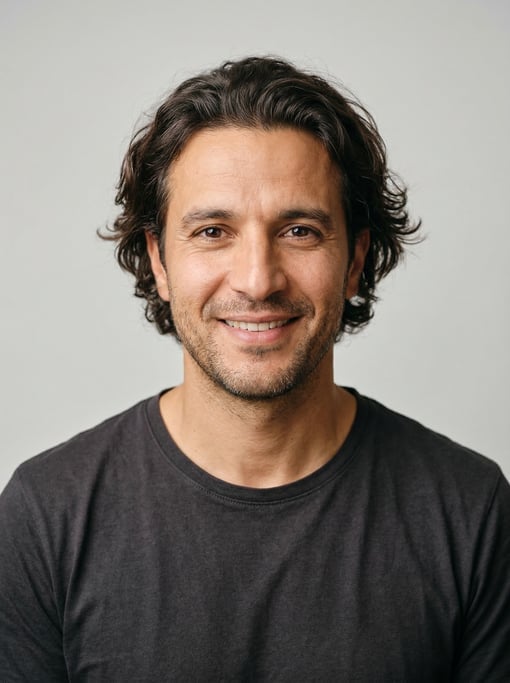 Professional studio headshot of a 40-year-old North African man with medium-length wavy dark brown h