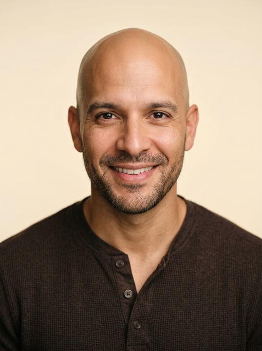 Professional studio headshot of a 40-year-old Puerto Rican man with a completely bald head