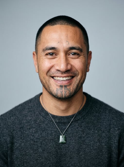 Professional studio headshot of a 40-year-old Maori man with a buzz cut in black