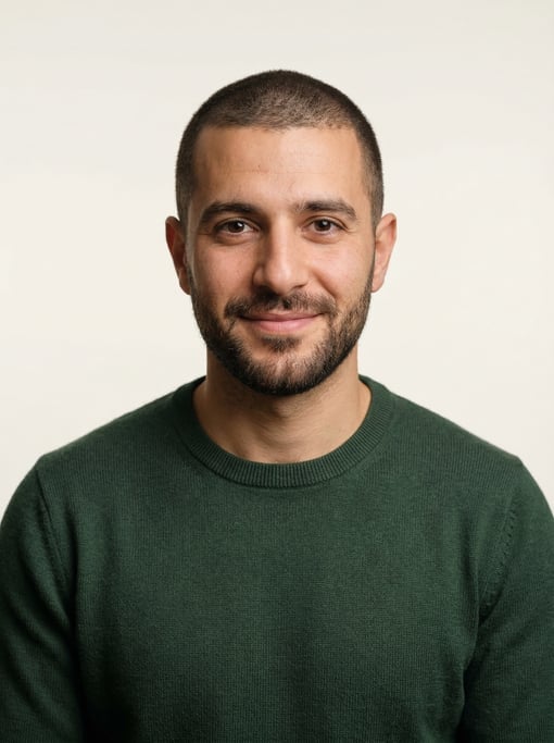 Professional studio headshot of a 31-year-old Lebanese man with a buzz cut in brown