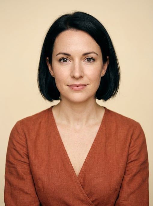 Professional studio headshot of a 33-year-old White British woman with a chin-length bob in jet blac