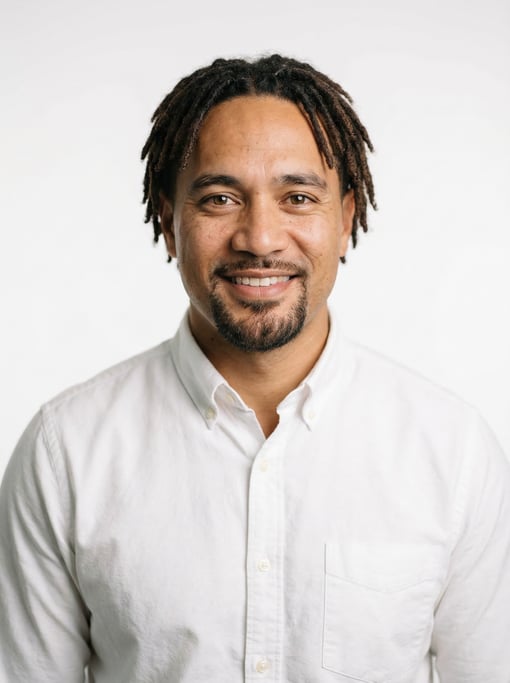 Professional studio headshot of a 38-year-old Polynesian man with short locs in dark brown