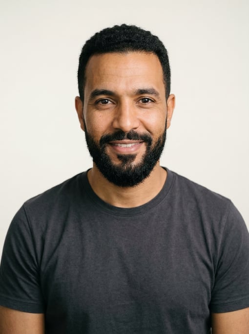 Professional studio headshot of a 38-year-old North African man with short textured black hair