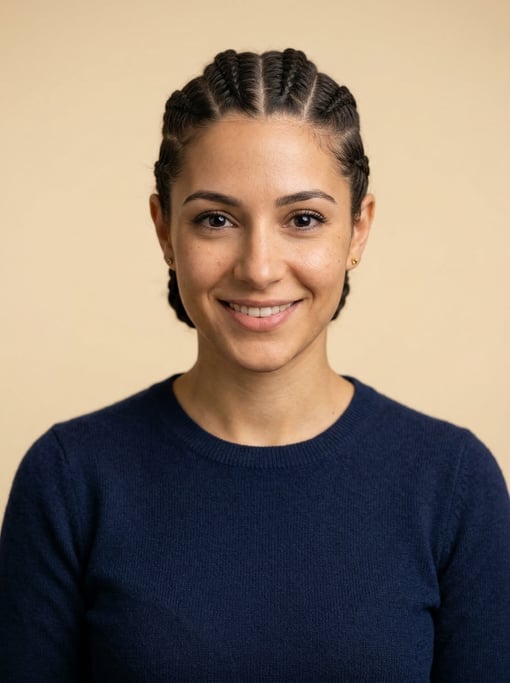 Professional studio headshot of a 25-year-old White Mediterranean woman with cornrows pulled back ne