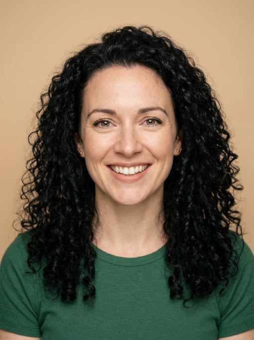 Professional studio headshot of a 33-year-old White British woman with long tight curls in black