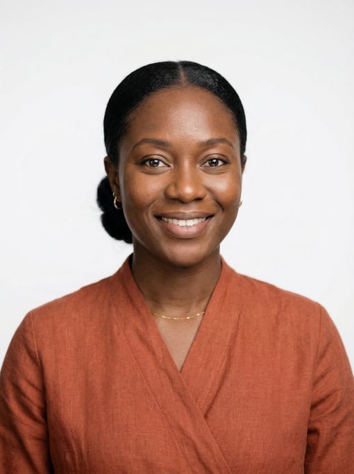 Professional studio headshot of a 31-year-old Ghanaian woman with a sleek low bun in black