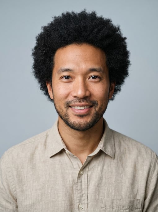 Professional studio headshot of a 36-year-old East Asian man with a medium natural afro in black